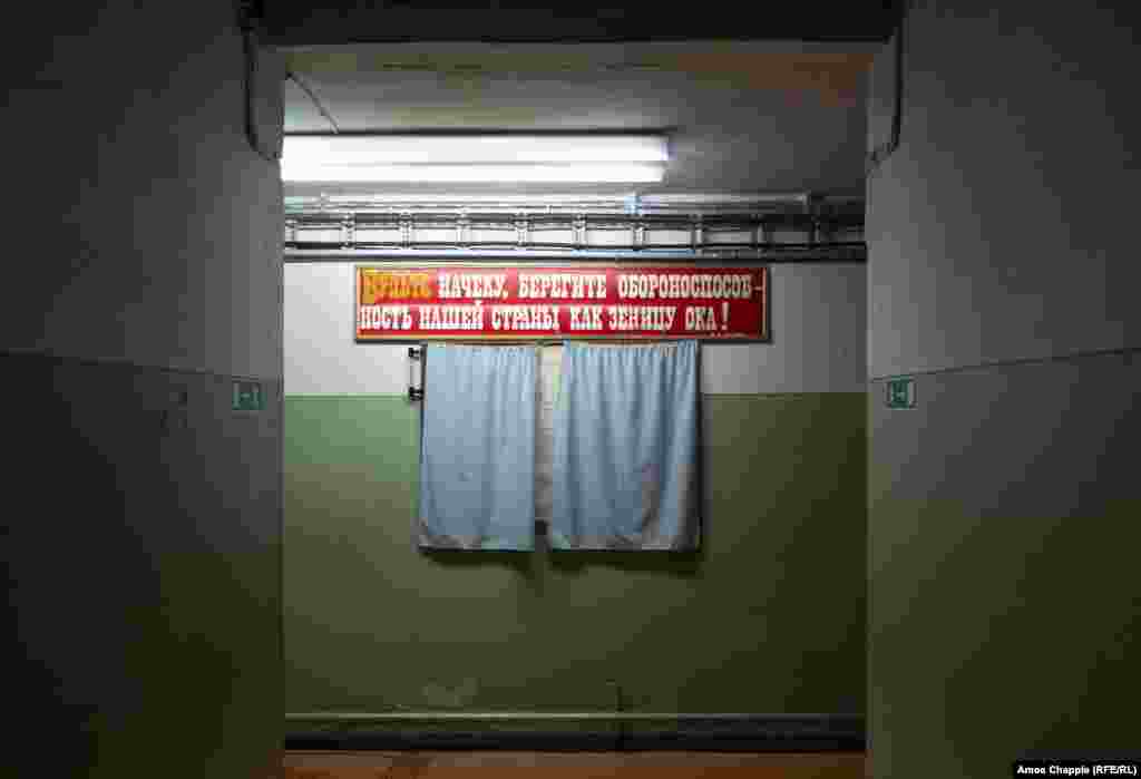 This banner urged loyal Soviets to “Be alert, guard the defense of our country like the apple of your eye!” The curtains conceal a plan of the bunker.
