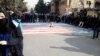 Students walk around, instead of across, U.S. and Israeli flags at the Shahid Beheshti University in Tehran on January 12. 