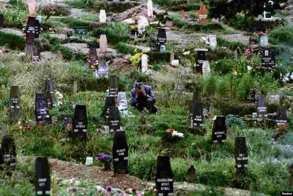 Saraýewonyň görülmedik derejede giňelen gonamçylyklarynyň birinde aýalynyň ýasyny tutýan adam. 1993. 