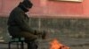 Житель города греется на улице у костра возле дома в Приозерске. Январь 2011 года. 