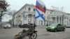 Проруски активист со руско знаме вози велосипед во Севастопол, град во Украина