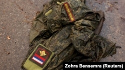 Военная форма лежит на дороге после уничтожения колонны российской бронетехники, апрель 2022 год
