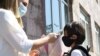 Armenia -- A teacher measures a first grader's temperature at the entrance to a school in Yerevan, September 14, 2020.