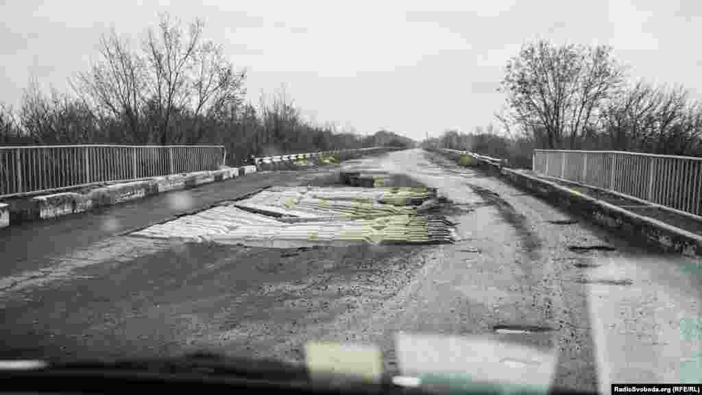 Дорога до міста Попасна всіяна &laquo;свідоцтвами&raquo; війни. Один із прикладів &ndash; цей зруйнований міст. Пасажири автобусів, що їздять цією дорогою, пішки проходять небезпечне місце, і тільки після цього повертаються в салон