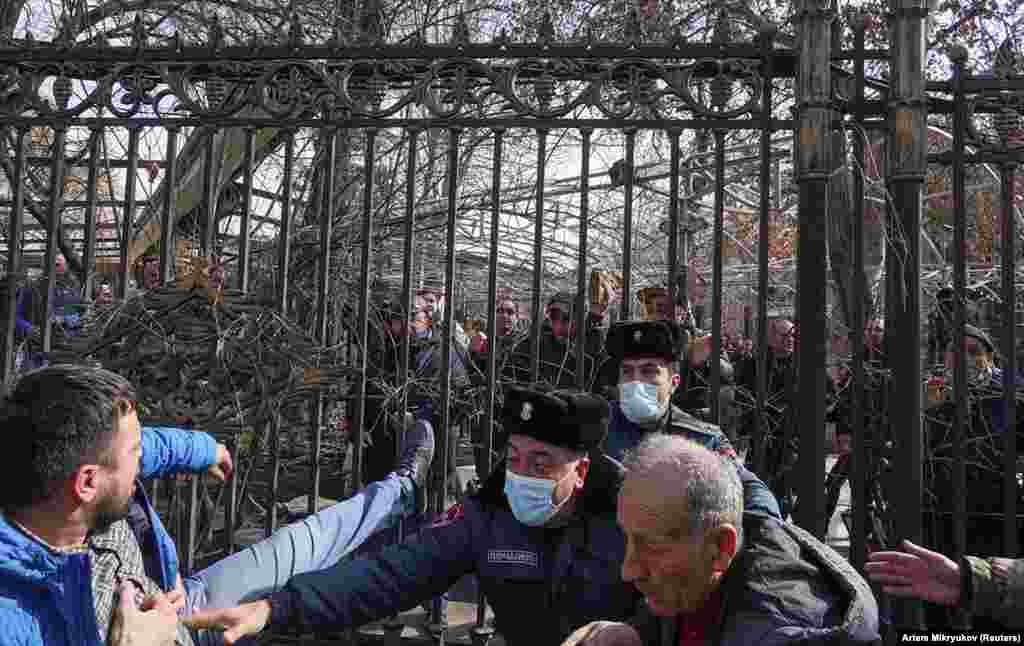 Police attempt to separate rival protesters. One of the men can be seen holding a rock. 