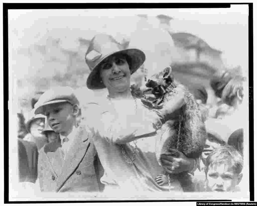 18 апреля 1927 года. Первая леди Грейс Кулидж, жена 30-го президента Калвина Кулиджа, во время Пасхального обеда в Белом доме показывает детям домашнего любимца семьи – енота Ребекку