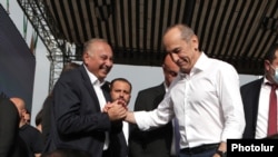 Former President Robert Kocharian (right) greets Armen Charchian, director of the Izmirlian Medical Center, during a rally in Yerevan in May.