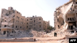 Syria -- People walk past a row of destroyed buildings near the Al-Hayat Hospital in the northern city of Aleppo, 10Sep2012