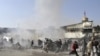 People react seconds after a suicide blast targeting a Shi'ite Muslim gathering in Kabul on December 6. Fifty-five people were killed and over 160 injured.