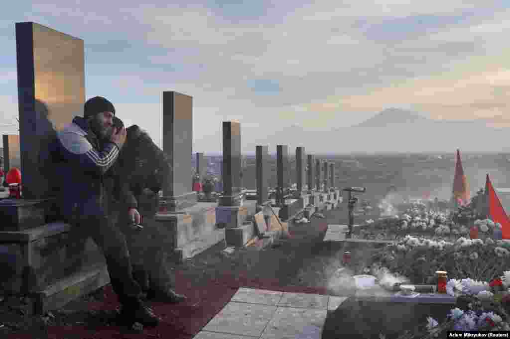 Men mourn a loved one at Yerablur cemetery on December 19. 