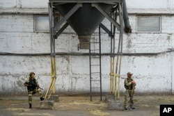 Російські солдати біля зернового елеватору у Мелітополі, 14 липня 2022 року