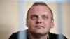 Dzmitry Halko sits in his cage in a Minsk court on July 17, 2018.