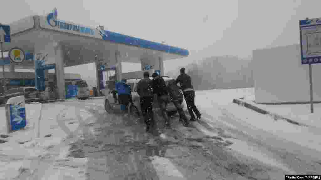A car needs a push to get up a small hill for a refill in Tajikistan's capital, Dushanbe.