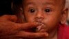 A malnourished child is fed at UNICEF medical center in Bangladesh.