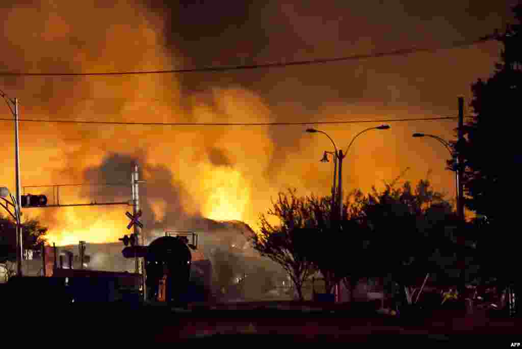 Firefighters douse blazes after a freight train loaded with oil derailed in Lac-Megantic in Canada's Quebec province, sparking explosions that engulfed about 30 buildings in fire. (AFP/François Laplante-Delagrave)