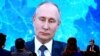 RUSSIA -- Journalists gather in front of a screen as they follow Russian President Vladimir Putin addressing his annual press conference via video link at the Novo-Ogaryovo state residence outside Moscow, December 17, 2020