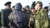 Observatorii militari OSCE încercînd să negocieze cu un militar pro-rus