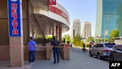 Kazakh special forces officers stand outside the Kaspi Bank building in Astana where a man held seven people hostage on June 18.