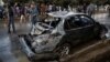 People look at a damaged vehicle after a deadly suicide bomb attack in Kabul on November 16.